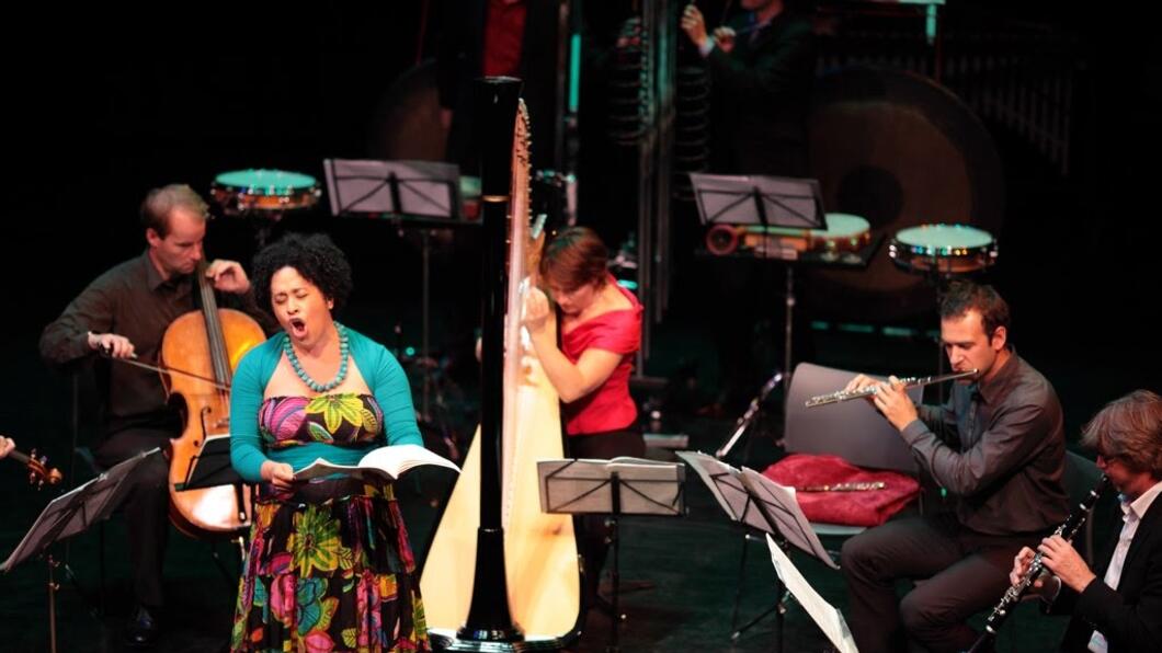 Een band maakt muziek, een vrouw zingt