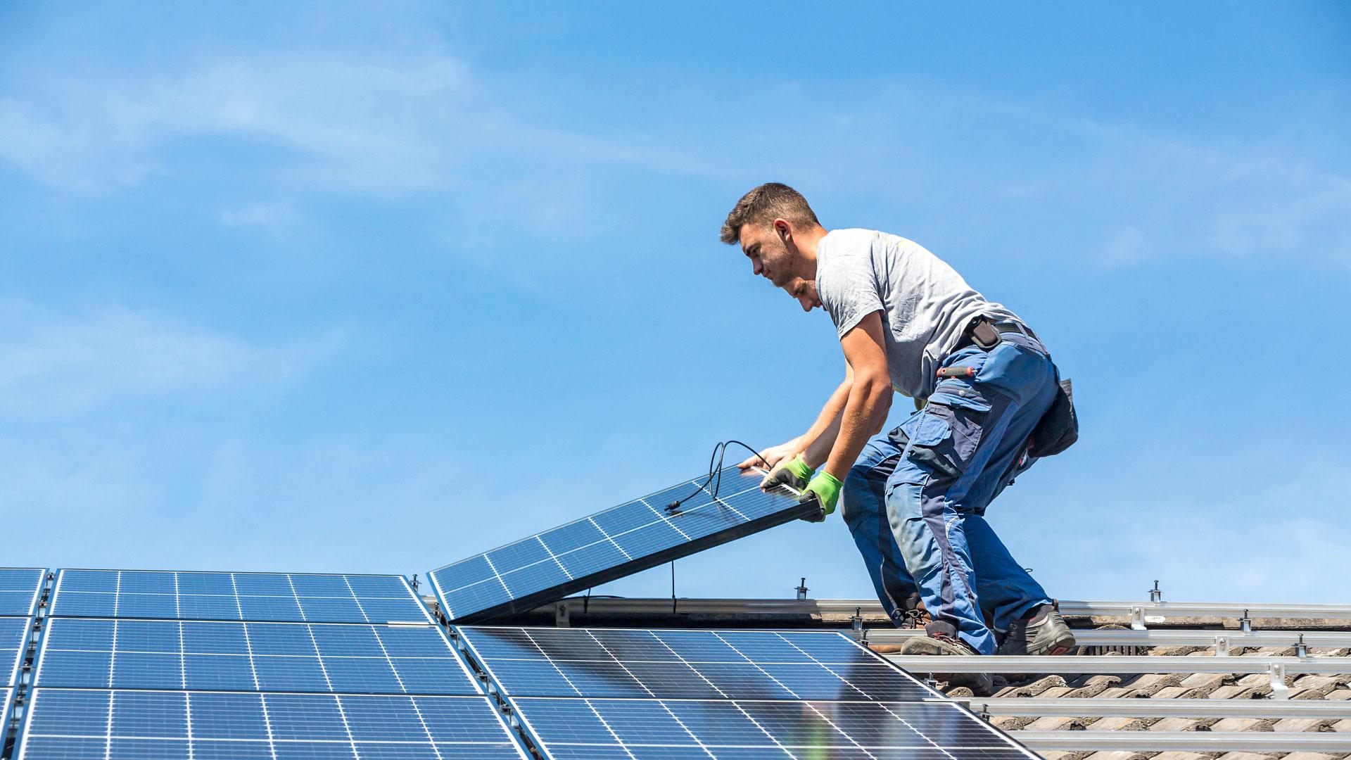 Twee installateurs leggen zonnepanelen op dak 